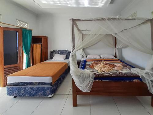 a bedroom with two beds with mosquito nets at Pondok Asri Homestay Munduk in Munduk