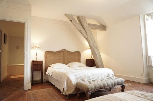 une chambre avec un grand lit avec une tête de lit en bois dans l'établissement Le Château, à Champagny-sous-Uxelles
