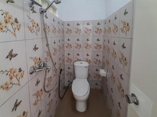 a bathroom with a toilet with butterflies on the wall at Pondok Asri Homestay Munduk in Munduk