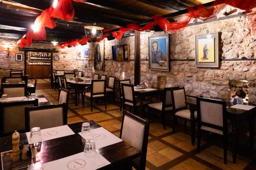 ein Restaurant mit Tischen, Stühlen und roten Bogen in der Unterkunft Ξενώνας Αρχοντικό Ελληνοπύργου in Ellinopyrgos