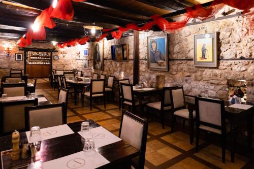 restauracja ze stołami, krzesłami i czerwonymi łukami w obiekcie Ξενώνας Αρχοντικό Ελληνοπύργου w mieście Ellinopyrgos