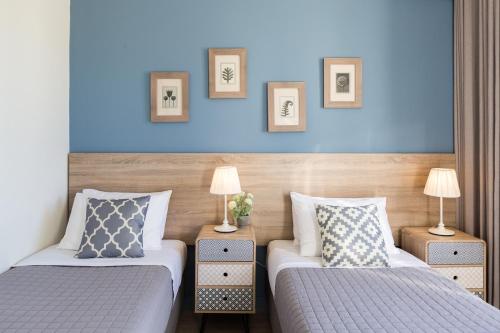 2 camas en una habitación de hotel con paredes azules en Effie's Cozy House, en Rethymno