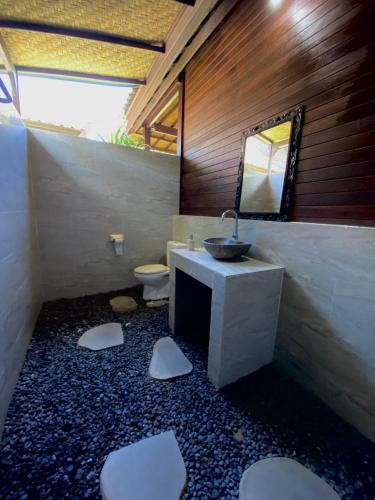 a bathroom with a sink and a toilet at Damara Lembongan in Nusa Lembongan