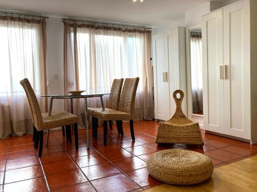 una sala da pranzo con tavolo, sedie e finestre di Apartamentos Ondoloin a Vitoria-Gasteiz