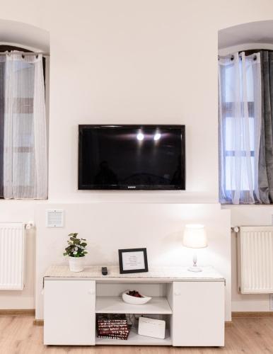 a white living room with a tv on the wall at Center feelings studio by Alandala in Cluj-Napoca