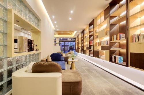 a library with bookshelves and chairs in a room at Wing Hotel Guilin- Pedestrian Street in Guilin