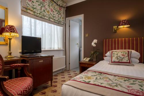 a hotel room with a bed and a television at London Lodge Hotel in London