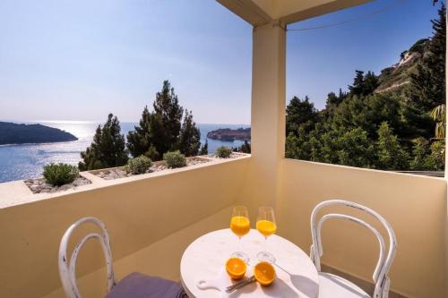 una mesa y sillas blancas con vistas al océano en Sea View Apartments, en Dubrovnik