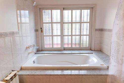 baño con bañera blanca y ventana en Amplio apartamento en pleno centro de Salta en Salta