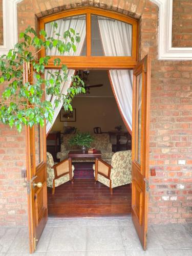 an open door to a patio with a table and chairs at Kimberley Club Guesthouse in Kimberley