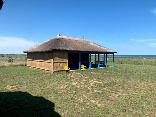 una piccola capanna con tetto di paglia in un campo di CORBU ACCOMMODATION a Corbu