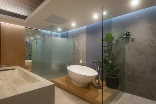 y baño con lavabo y ducha acristalada. en Ballito Sands Penthouses, en Ballito