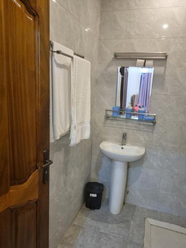 ダカールにあるresidence mounaのバスルーム(白い洗面台、鏡付)