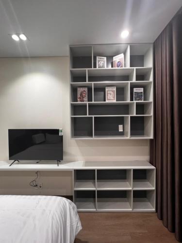 a bedroom with a bed and a desk with a television at Marina Golfview in Ðố Sơn