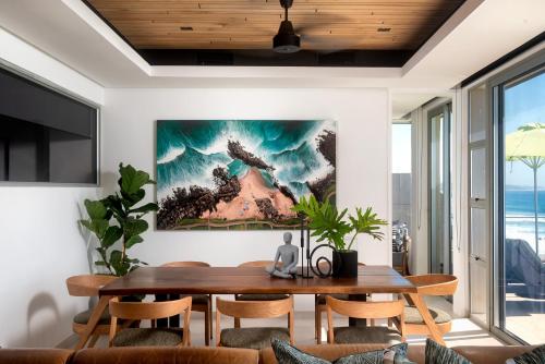 un comedor con una mesa y una pintura en la pared en Ballito Sands Penthouses, en Ballito