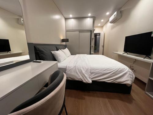 a bedroom with a bed and a flat screen tv at Marina Golfview in Ðố Sơn