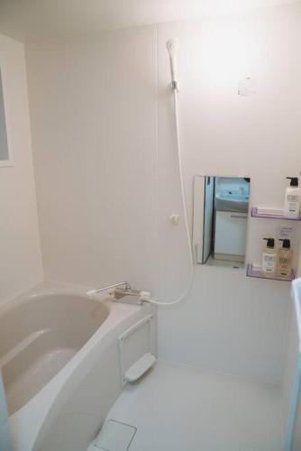 a white bathroom with a sink and a mirror at Kokoro no sato・Tsuki in Kyoto