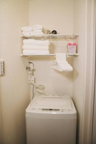 a small bathroom with a washing machine and towels at Kokoro no sato・Tsuki in Kyoto