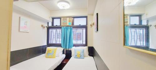 Pokój z dwoma białymi kanapami i dwoma oknami w obiekcie Apple Hostel w Hongkongu