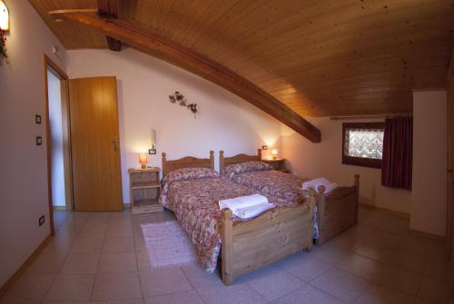 a bedroom with a large bed and a wooden ceiling at B&B Casa Zeni in Faedo