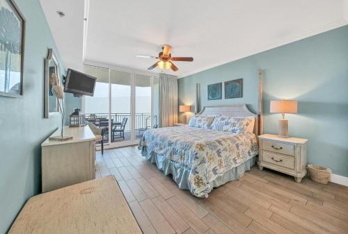 een slaapkamer met een bed, een televisie en een balkon bij Incredible Courtyard Pools and Gulf Views Waterscape C506 Sleeps 10 in Fort Walton Beach
