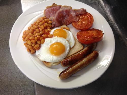 a plate of breakfast food with eggs sausage beans and tomatoes at Villa Bianca B&B in Penrith