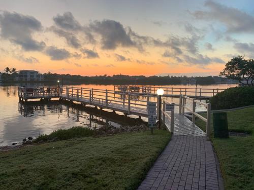 a dock on a body of water with a sunset at Charming Two Bedroom Condo With Pool View Siesta Key Bay Oaks in Siesta Key