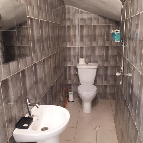 a bathroom with a toilet and a sink at ZAC MBAO - Cité enseignants in Kammba