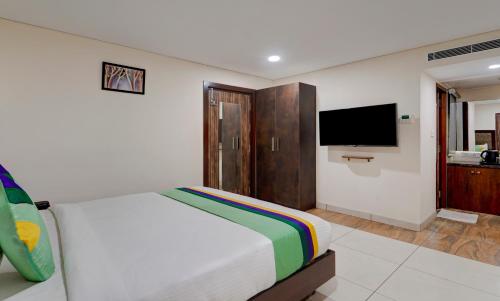 a bedroom with a bed and a flat screen tv at Treebo Vetri Supreme Residency in Chennai