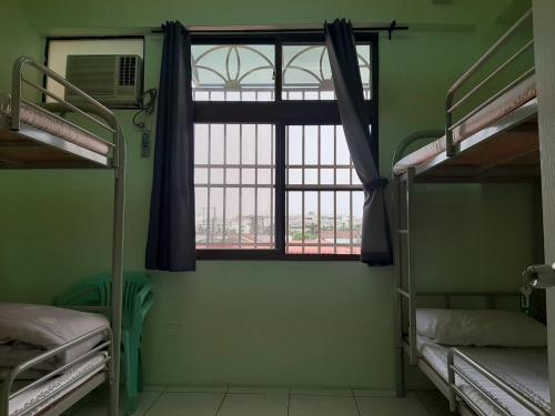 萬巒鄉的住宿－蘇馬利萬巒民宿，客房设有两张双层床和一扇窗户。
