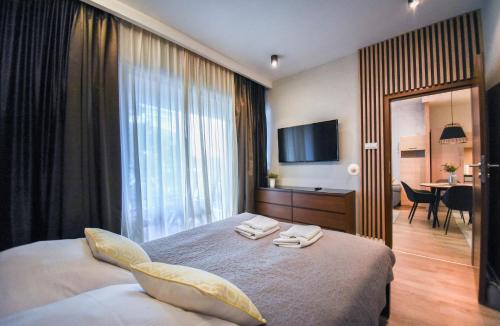 a bedroom with a bed with two towels on it at Apartamenty Na Wyspie - Baltic Park - Apartamenty z sypialnią i parkingiem - ul Uzdrowiskowa 24-34 in Świnoujście