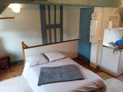 una camera con un letto e una porta blu di La Petite Parenthèse a Honfleur