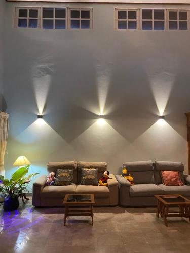 two couches in a room with lights on the wall at Let's Chill Pool Villa Pattaya Najomtien42 and Sattahip in Ban Tao Than