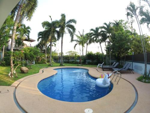 a swimming pool with a white swan in a yard at Let's Chill Pool Villa Pattaya Najomtien42 and Sattahip in Ban Tao Than