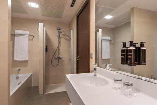 ein weißes Bad mit einem Waschbecken und einer Dusche in der Unterkunft Eurostars Vía de la Plata in Astorga