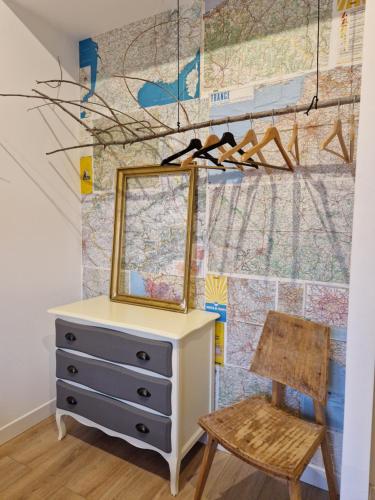 a dresser with a mirror and a chair in a room at Maison Brisson in Talence