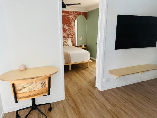 a room with a desk and a tv and a bed at Tessa's on the Beach in Gold Coast