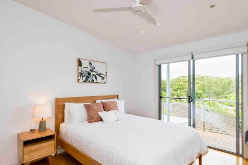 黄金海岸Large Tugun Modern House minutes to the beach的一间带床和窗户的白色卧室