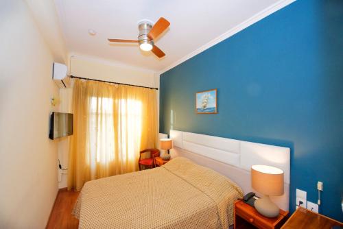 a bedroom with a bed and a blue wall at Hotel Dalia in Corfu Town