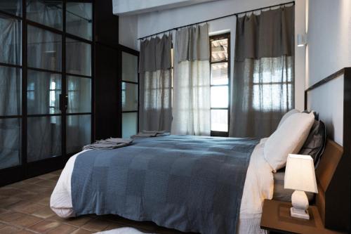 a bedroom with a large bed and windows at Casa Kiko Pecetto in Pecetto