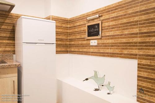 マラガにあるLiving4Malaga Boutique Apartmentsの冷蔵庫付きのキッチン(壁に看板あり)