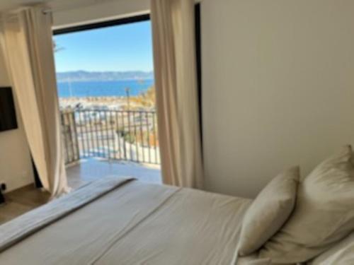 a bedroom with a bed and a view of the ocean at Le retour in Saint-Cyr-sur-Mer