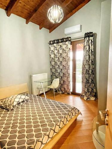 a bedroom with a bed and a chair and a window at Kathiana cozy apartment in Kathiana