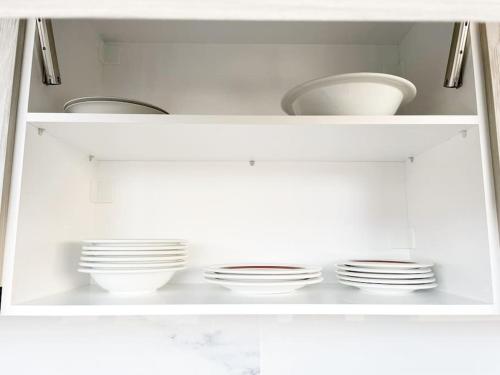 a white cabinet with plates and bowls in it at Kathiana cozy apartment in Kathiana