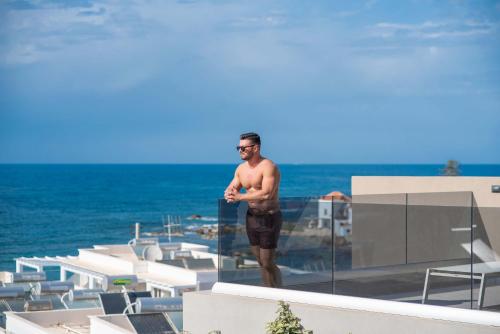 a man standing on top of a building at Seafront Villas I Luxury stay next to the sea in Chania Town