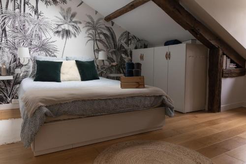 a bedroom with a bed with green and white pillows at Maison dans le centre historique pour 6 personnes avec terrasse et parking in Pau