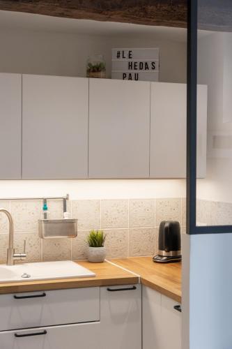 a kitchen with white cabinets and a sink at Maison dans le centre historique pour 6 personnes avec terrasse et parking in Pau