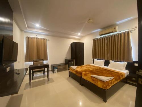 a bedroom with a bed and a flat screen tv at SHLOKA RESIDENCY in Shamshabad