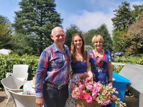 a man and two women holding a basket of flowers at Green Lantern Inn in Van Reenen