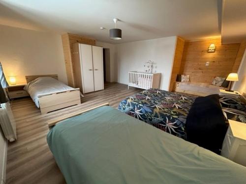 um quarto com 2 camas e um berço em Appartement 6/8 personnes 